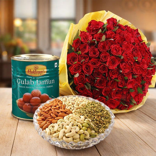 Bouquet of red roses, Haldiram's Gulab Jamun, and a plate of assorted nuts on a wooden surface.