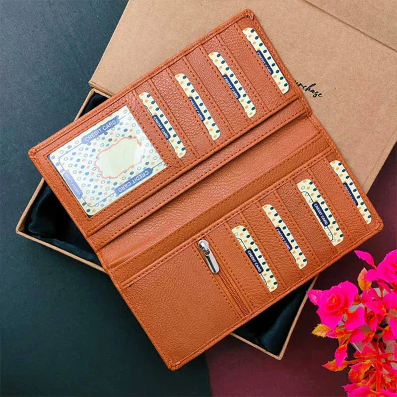 Brown leather wallet with decorative elements on a dark surface with a pink flower.
