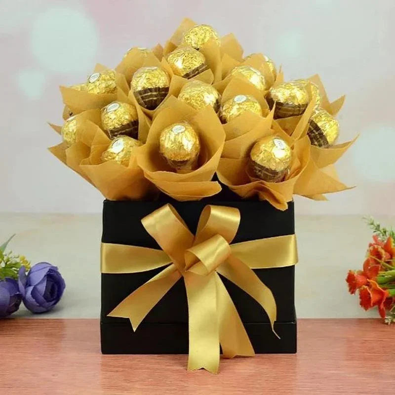 Bouquet of Ferrero Rocher chocolates in a decorative box with a gold bow on a wooden surface.