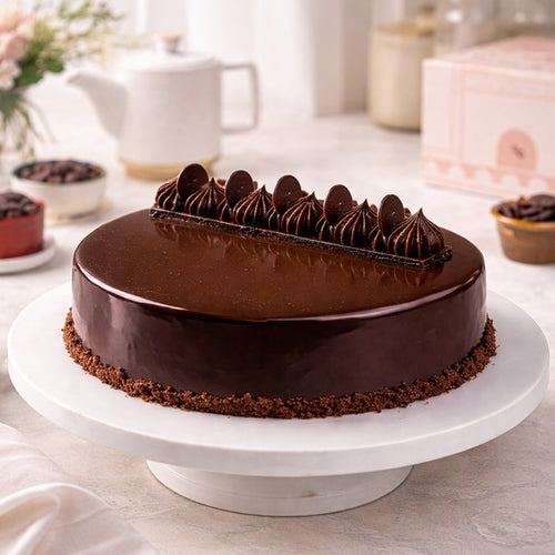 Chocolate cake on a white cake stand with a blurred background