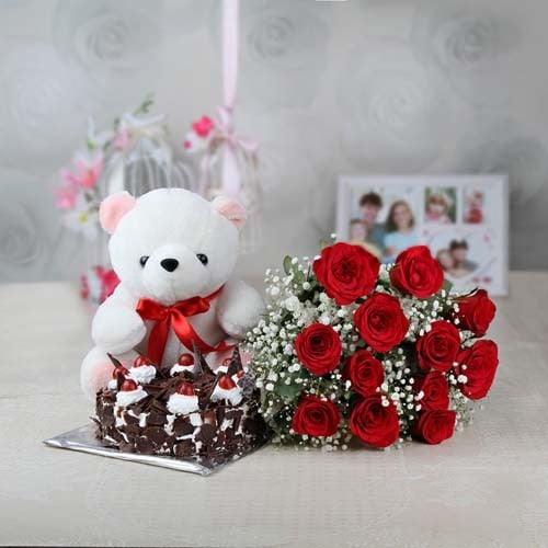Teddy bear with red rose bouquet and chocolate cake on a table, gift set arrangement