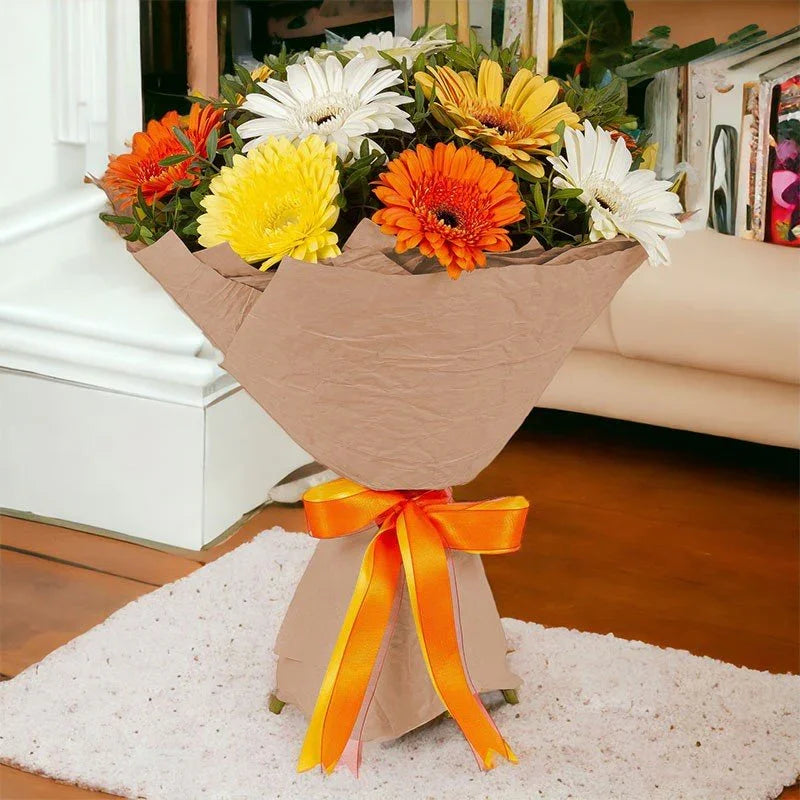 Colorful gerbera daisy bouquet wrapped in paper with orange ribbon, placed in living room