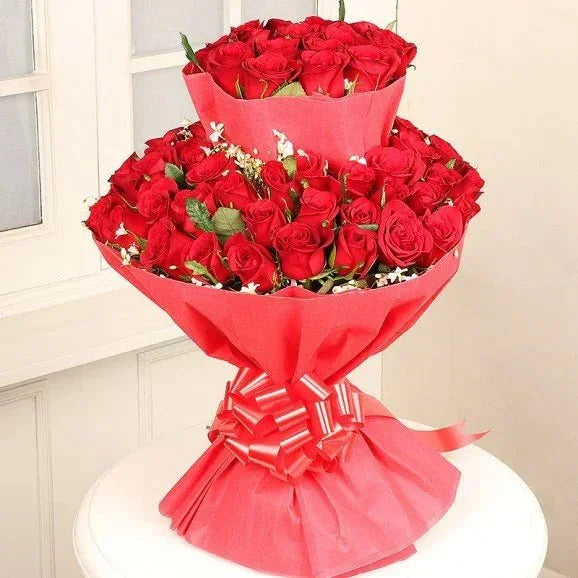 Elegant two-tier bouquet of red roses wrapped in pink paper, perfect for gifting occasions