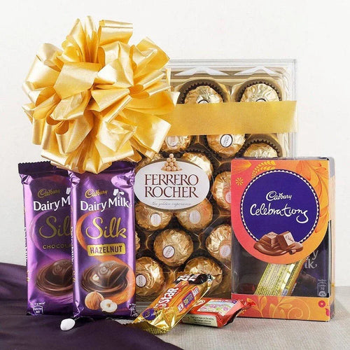 Assorted chocolate gift set with Cadbury Dairy Milk, Ferrero Rocher, and Cadbury Celebrations on a white background.