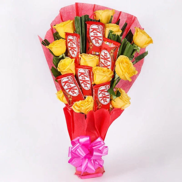 Bouquet of yellow roses and KitKat bars wrapped in red paper with a pink bow on a white background