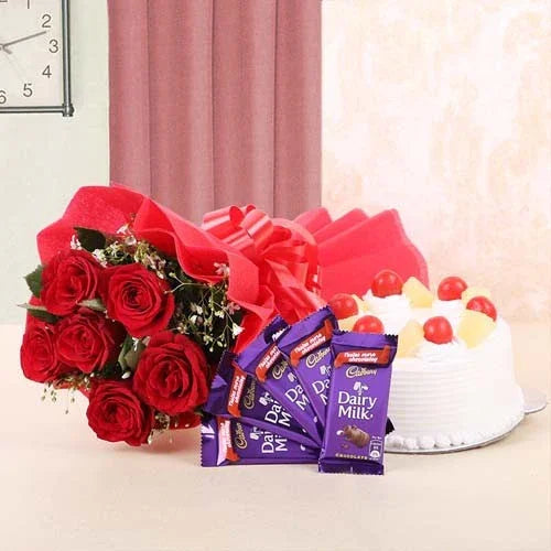 Bouquet of red roses, pineapple cake, and Dairy Milk chocolates, ideal for gifting occasions.