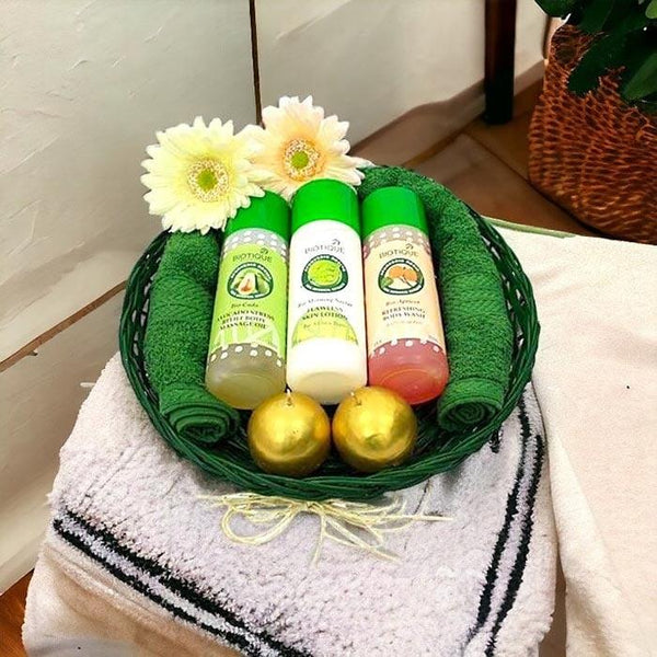 Spa gift basket with Biotique bath products, towels, flowers, and golden balls on white towel