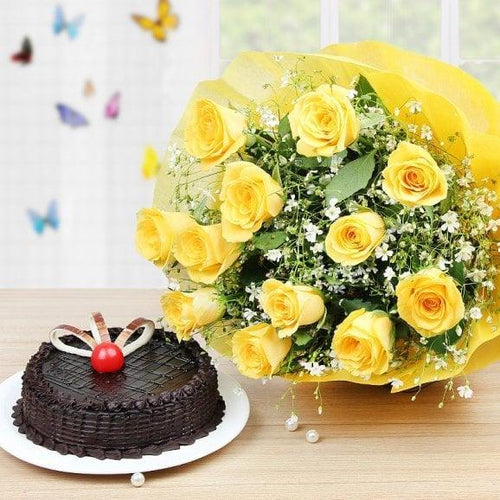 Bouquet of yellow roses and a chocolate cake on a wooden 