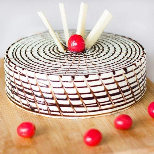 Decorative cake with chocolate and white icing on a wooden surface