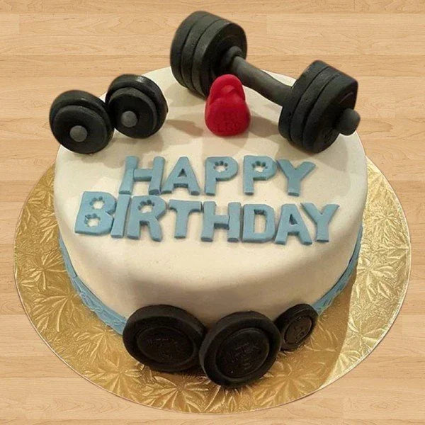 Birthday cake with barbell and dumbbells on top, featuring 'Happy Birthday' text.